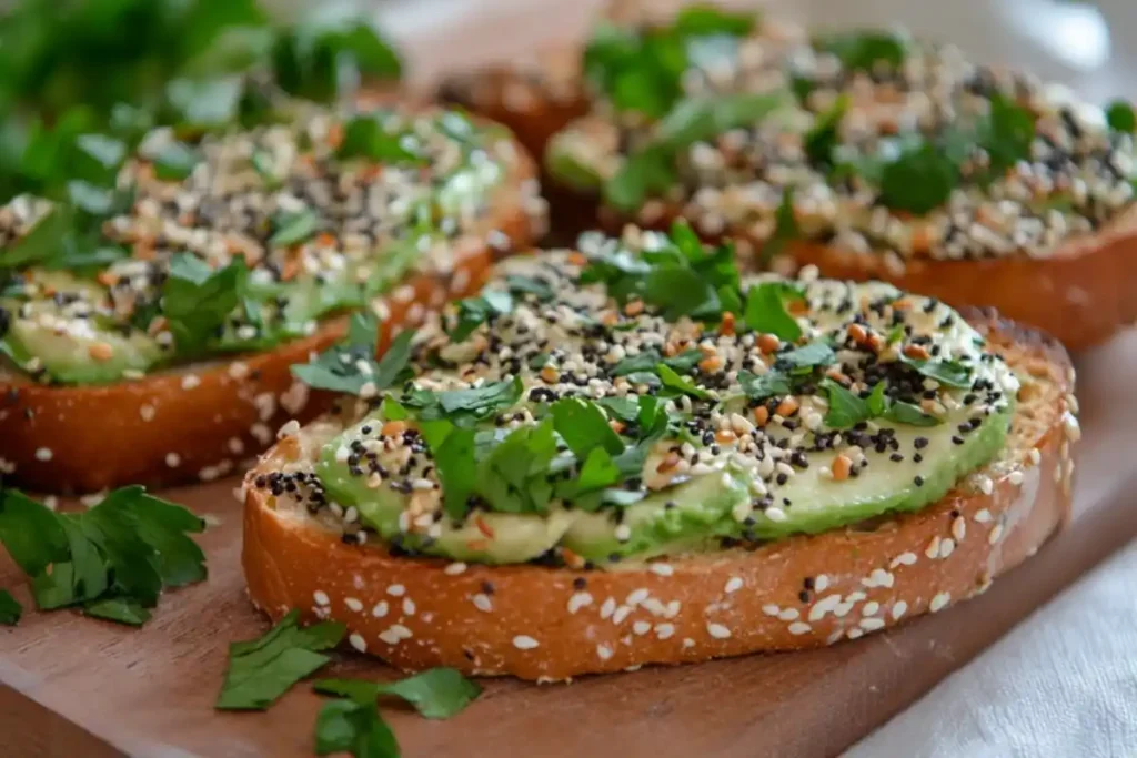 A vibrant avocado toast topped with everything bagel seasoning and herbs.